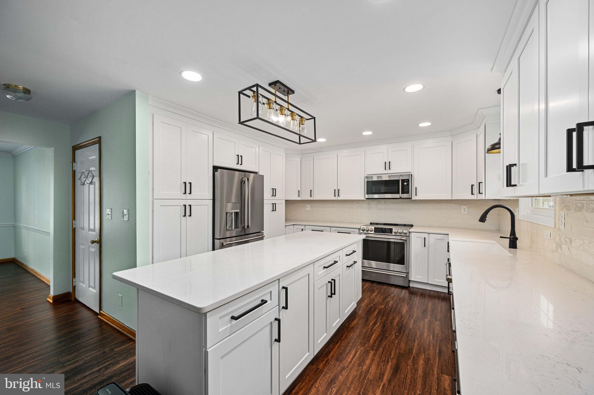 95 Potomac Lane Colonial Beach, VA 22443 - Photo 52 of 101 a kitchen with stainless steel appliances granite countertop a stove top oven a refrigerator a sink and dishwasher with wooden floor