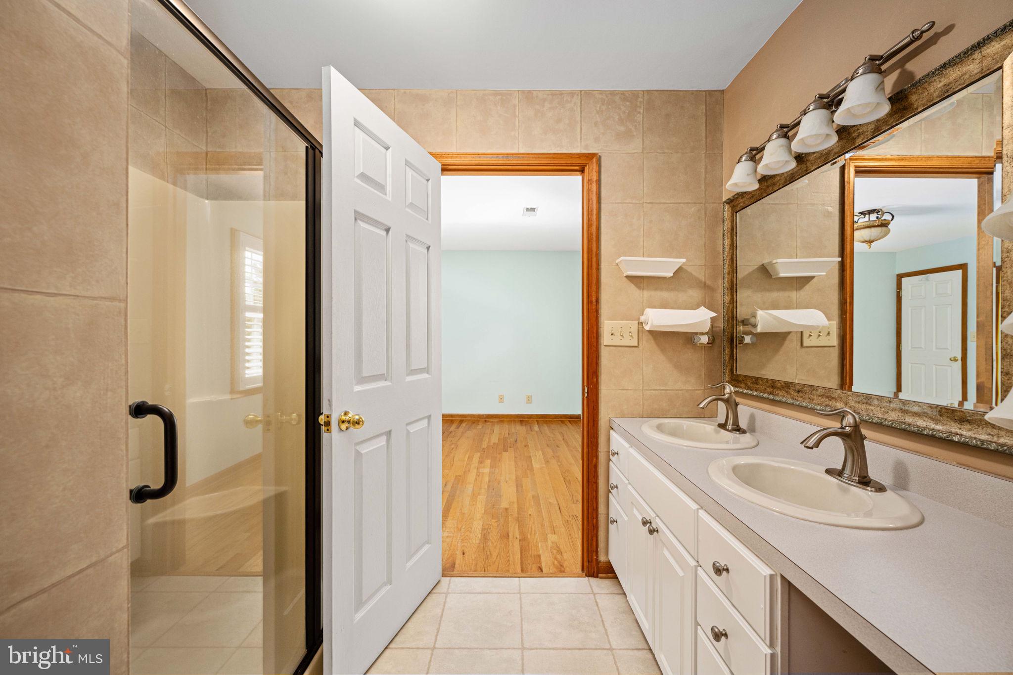 95 Potomac Lane Colonial Beach, VA 22443 - Photo 88 of 101 a bathroom with a double vanity sink a mirror and a shower
