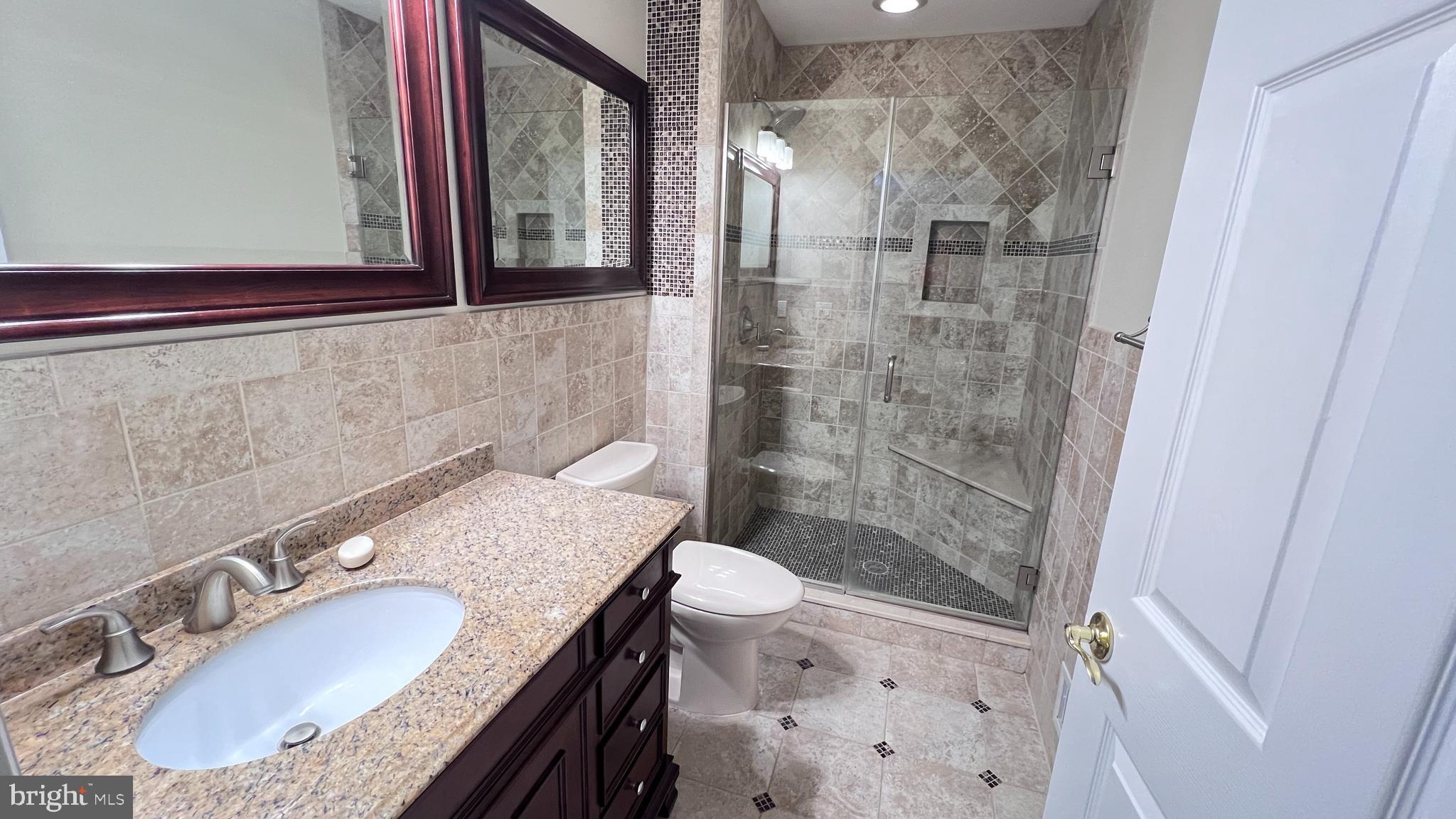 7 Voscek Court Lawrence Township, NJ 08648 - Photo 7 of 19 a bathroom with a granite countertop sink a toilet a mirror and shower
