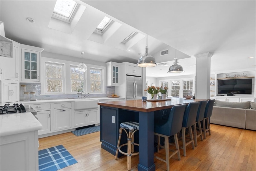 8 Village Lane Hingham, MA 02043 - Photo 11 of 36 a kitchen with stainless steel appliances granite countertop a stove a sink dishwasher a dining table and chairs with wooden floor
