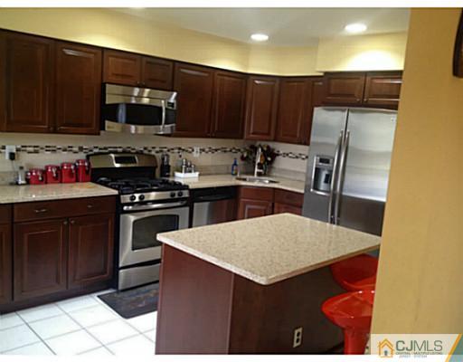 179 Salem Road North Brunswick, NJ 08902 - Photo 4 of 23 a kitchen with stainless steel appliances a stove a sink a microwave a refrigerator and cabinets