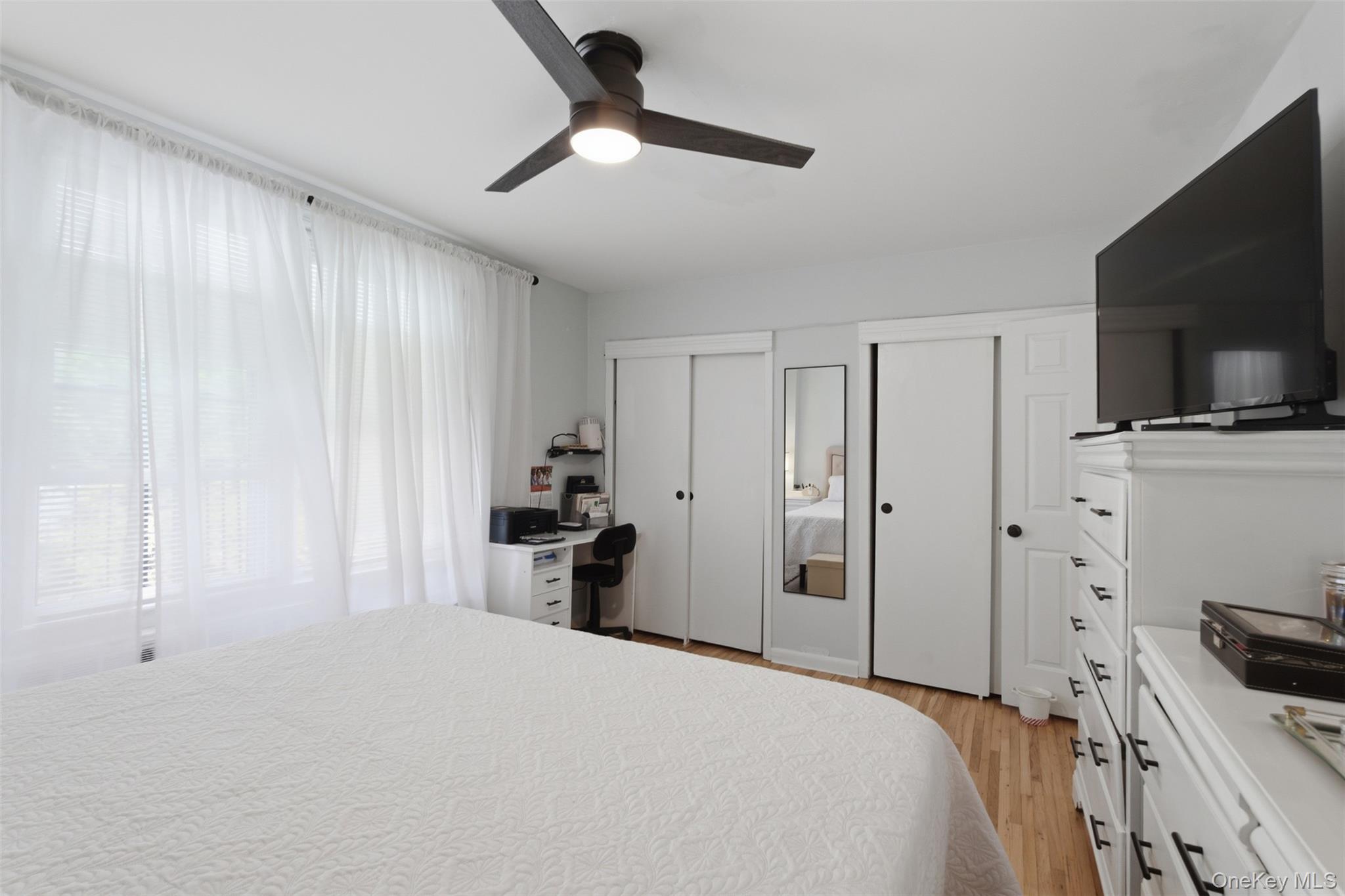 25 Trinity Place, Unit 2K New Rochelle, NY 10805 - Photo 17 of 25 Bedroom featuring hardwood floors, a ceiling fan, and double closets.