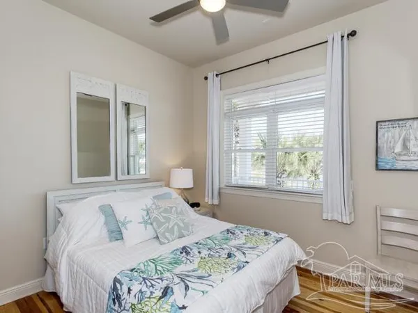 a bedroom with a bed and a window with chair