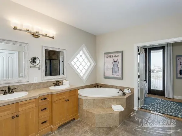 a bathroom with a tub sink and mirror