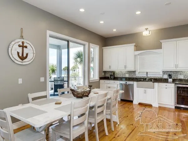 a kitchen with a dining table chairs and white appliances