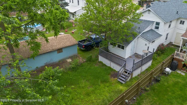 an aerial view of a house with swimming pool and garden