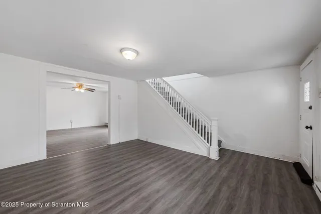 a view of an empty room with wooden floor
