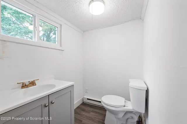 a bathroom with a sink a toilet and a window