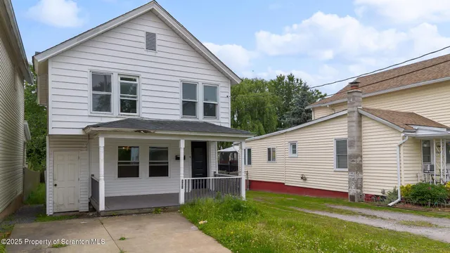 a view of a house with a yard and sitting area