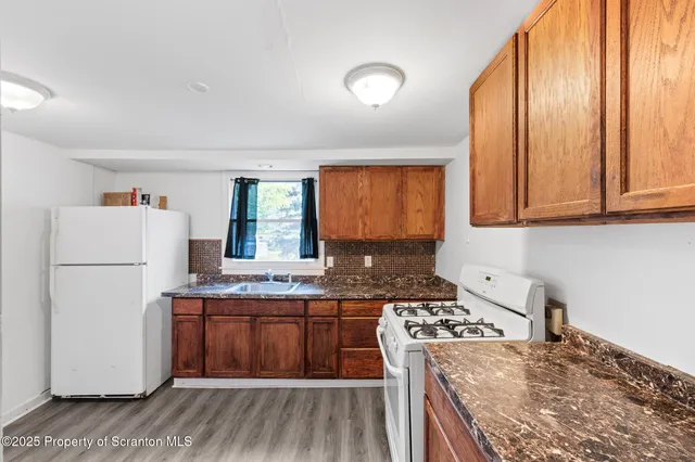 a kitchen with a stove a sink and a refrigerator