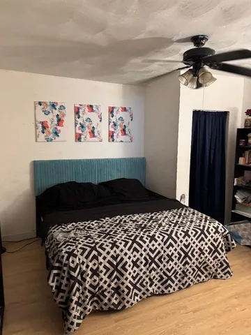 a bedroom with a bed and a wall painting