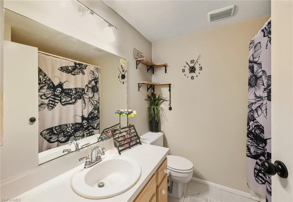 2747 47th Street Southwest Naples, FL 34116 - Photo 15 of 21 a bathroom with a sink toilet and shower curtain