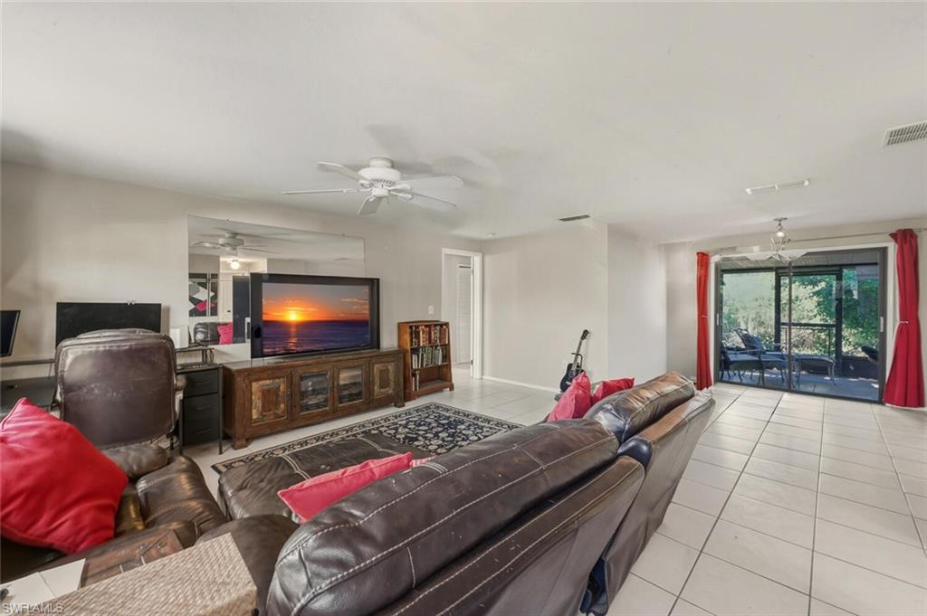 2747 47th Street Southwest Naples, FL 34116 - Photo 2 of 21 a living room with furniture and a flat screen tv