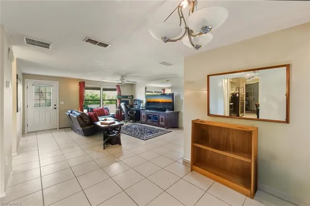 a kitchen with stainless steel appliances kitchen island granite countertop a dining table chairs refrigerator and sink