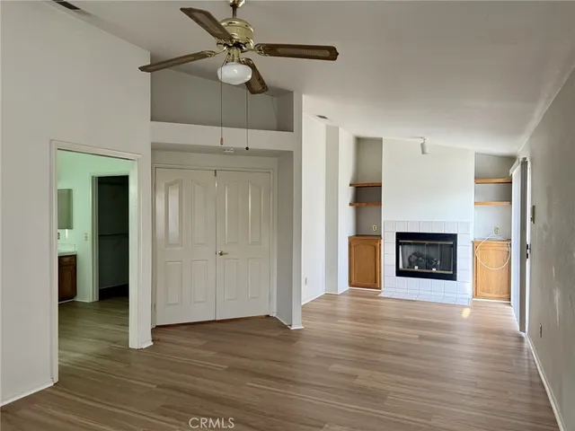 a view of a livingroom with a fireplace and a chandelier fan