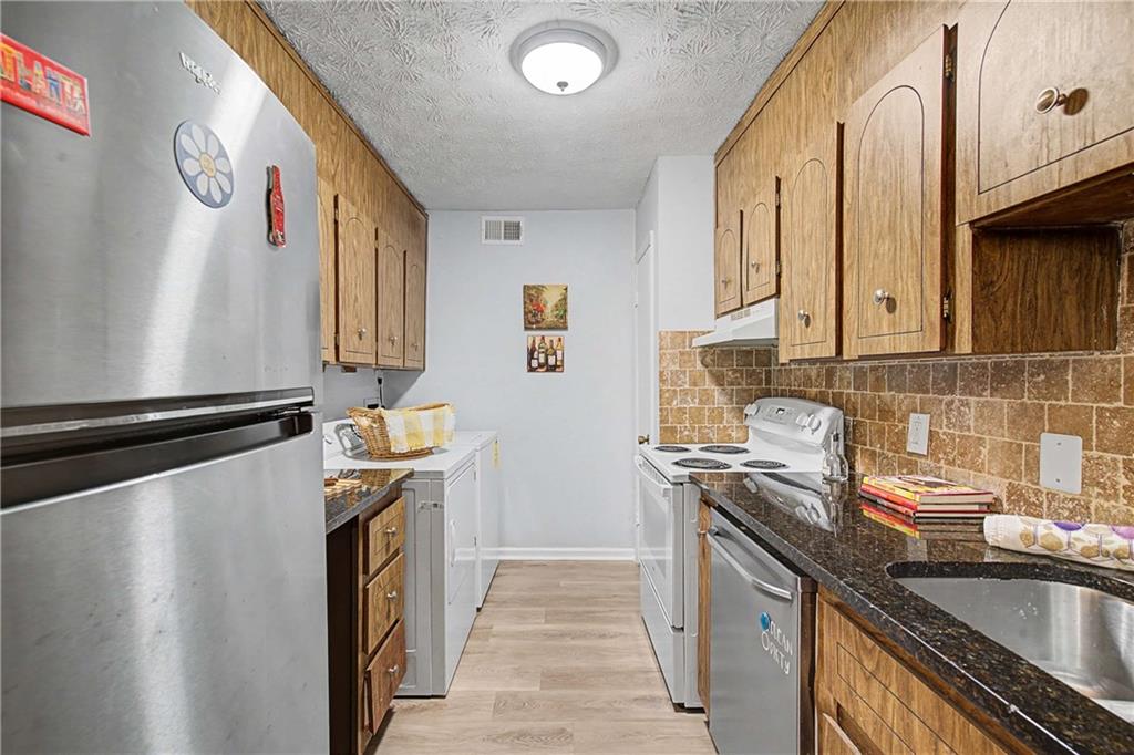 2396 Lawrenceville Highway, Unit G Decatur, GA 30033 - Photo 17 of 30 a kitchen with stainless steel appliances granite countertop a sink stove and refrigerator