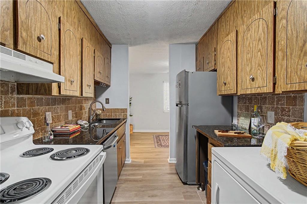 2396 Lawrenceville Highway, Unit G Decatur, GA 30033 - Photo 18 of 30 a kitchen with stainless steel appliances granite countertop a sink stove and refrigerator