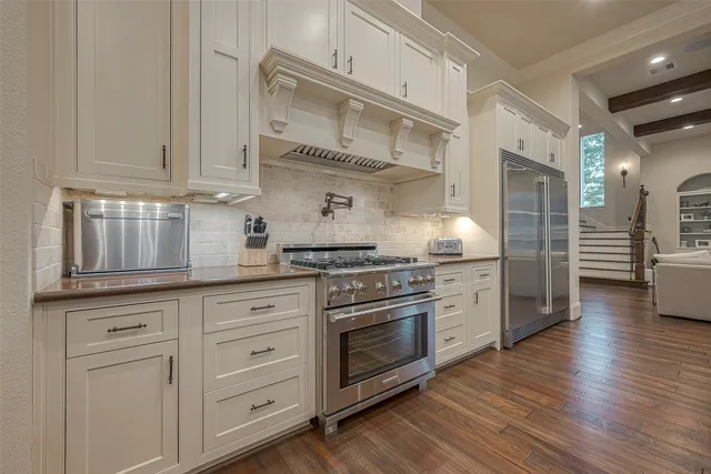 a kitchen with stainless steel appliances granite countertop a stove oven and white cabinets