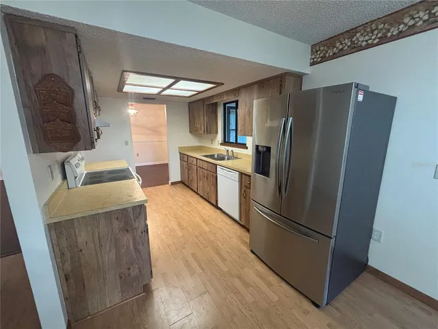 a kitchen with stainless steel appliances granite countertop a refrigerator and a sink