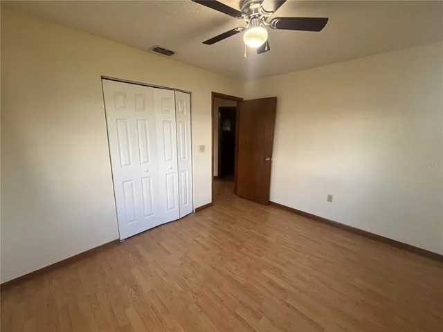an empty room with a ceiling fan and a window