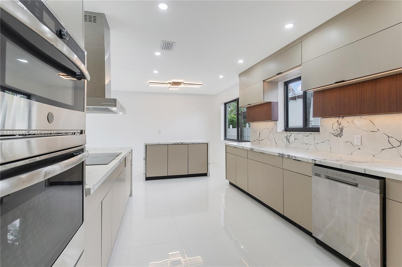 1200 Cleveland Road Miami Beach, FL 33141 - Photo 16 of 41 a large white kitchen with a sink and dishwasher a stove top oven with wooden floor