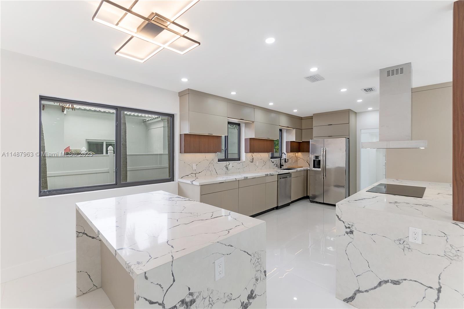 1200 Cleveland Road Miami Beach, FL 33141 - Photo 10 of 41 a large white kitchen with sink and refrigerator