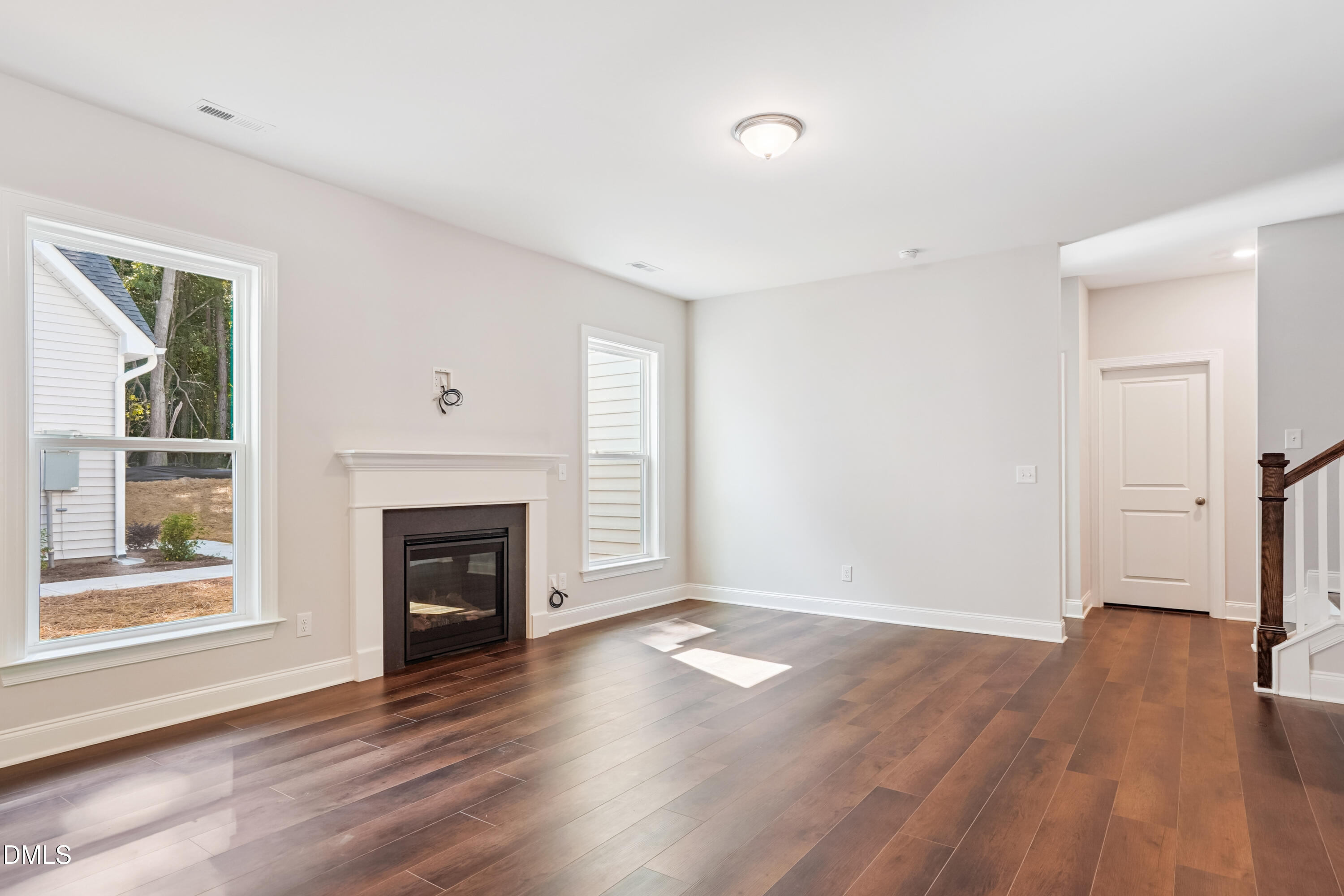 4921 Theater Way Raleigh, NC 27604 - Photo 18 of 26 an empty room with wooden floor fireplace and windows