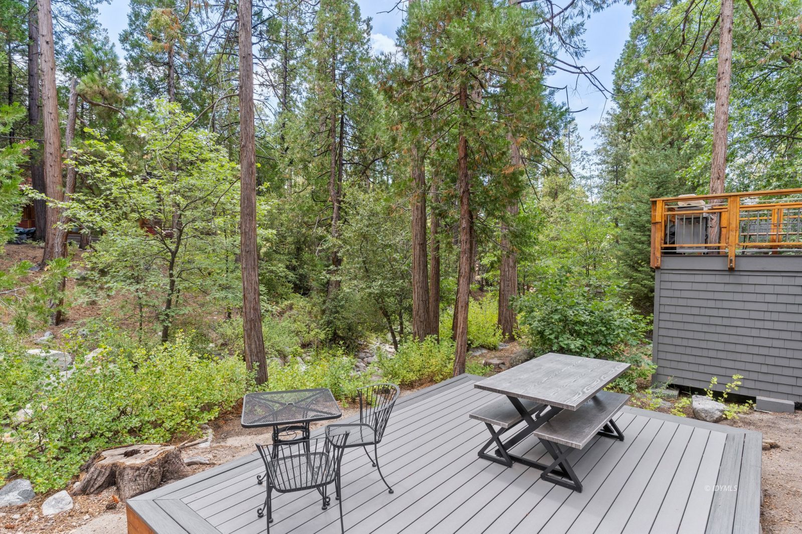 25010 Tahquitz Road Idyllwild, CA 92549 - Photo 66 of 93 a view of a patio with table and chairs and potted plants with wooden floor and fence