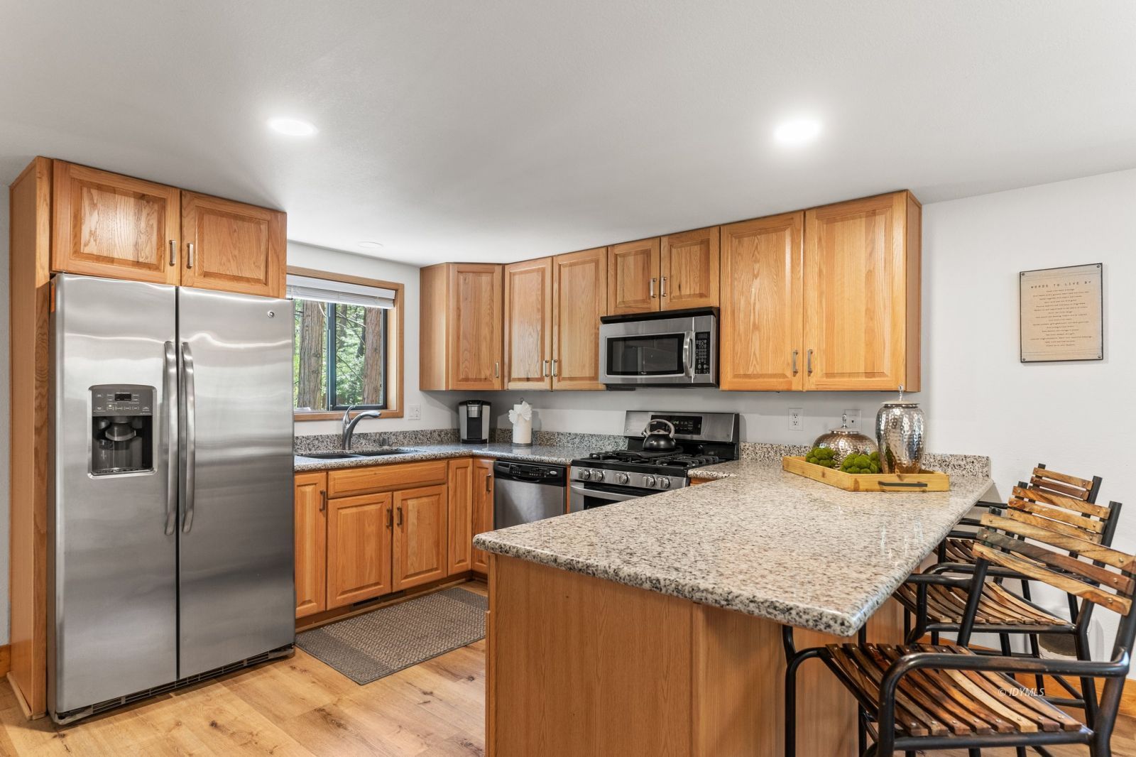 25010 Tahquitz Road Idyllwild, CA 92549 - Photo 71 of 93 a kitchen with stainless steel appliances granite countertop a refrigerator a stove a sink a dining table and chairs with wooden floor