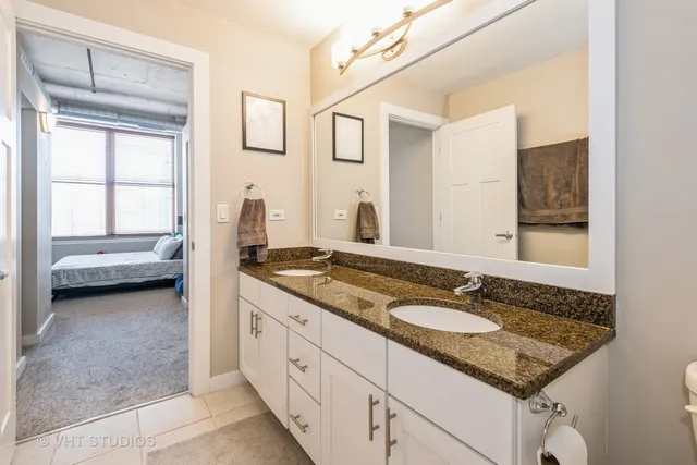 a bathroom with a granite countertop sink and a mirror