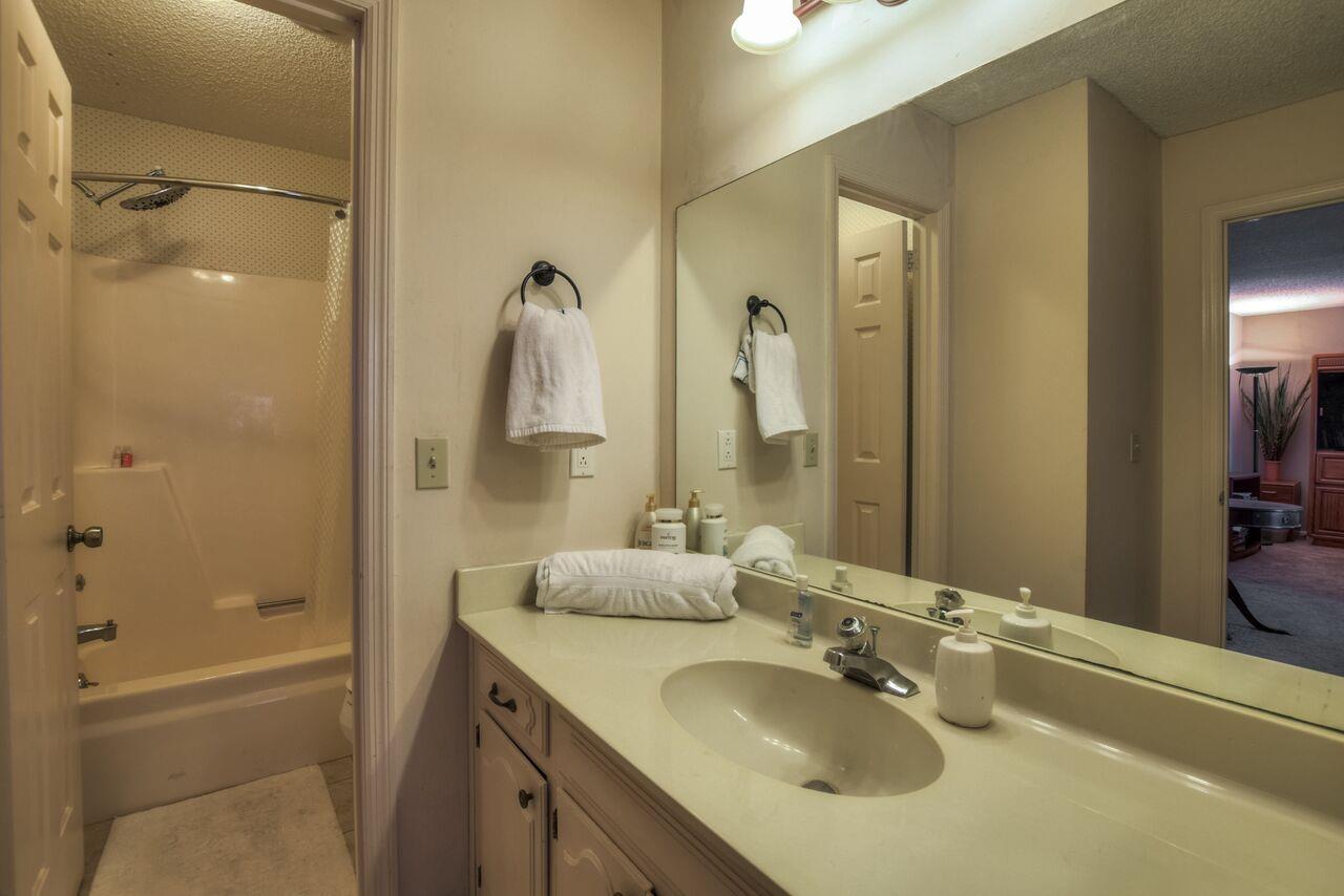 4001 Anderson Road, Unit B128 Nashville, TN 37217 - Photo 17 of 21 a bathroom with a granite countertop sink shower and a mirror