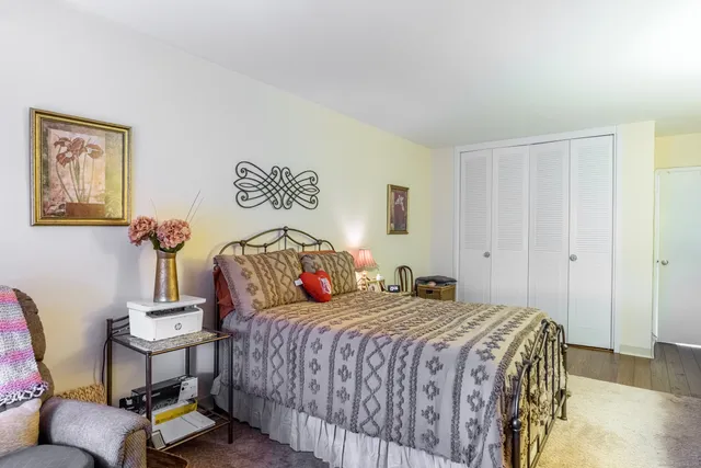 a bedroom with a bed and a lamp on dresser