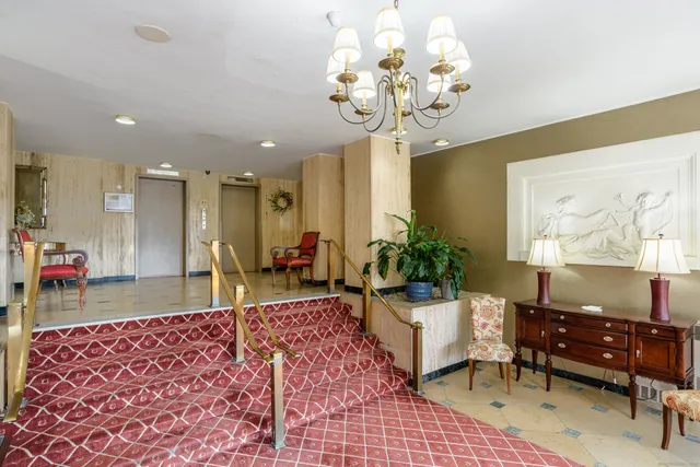 a living room with dining table and a chandelier