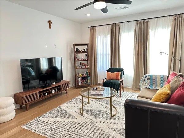 a living room with stainless steel appliances furniture and a view of kitchen