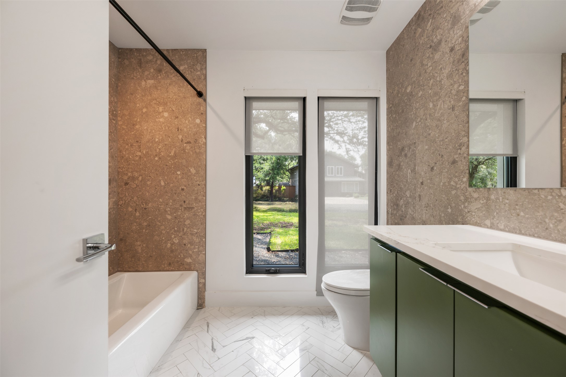 8900 Point W Drive Austin, TX 78759 - Photo 35 of 40 Herringbone tiled floors and a chic green vanity create a tranquil bath space.