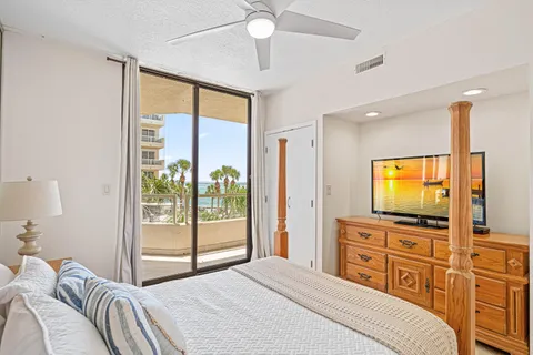a bedroom with a bed and a flat tv screen on dresser