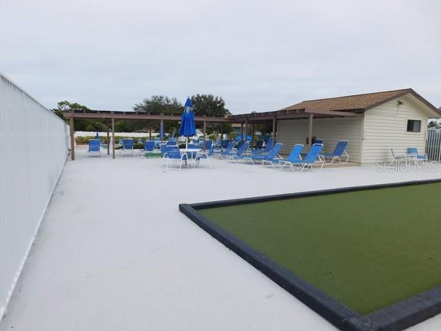 716 White Pine Tree Road, Unit 79 Venice, FL 34285 - Photo 19 of 22 a view of swimming pool with outdoor seating and trees in the background