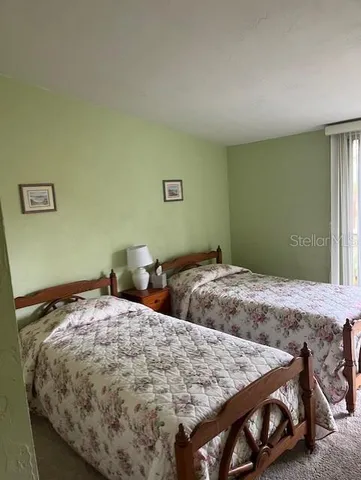 a bedroom with 2 bed and a window