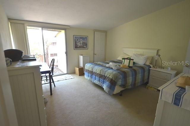 716 White Pine Tree Road, Unit 79 Venice, FL 34285 - Photo 9 of 22 a bedroom with a bed and a table in it