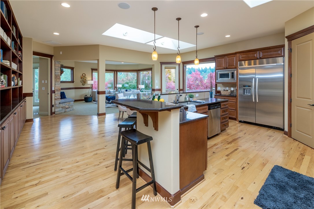 1710 Kitsap Place Northeast Renton, WA 98059 - Photo 8 of 37 a kitchen with stainless steel appliances granite countertop a table chairs and a refrigerator