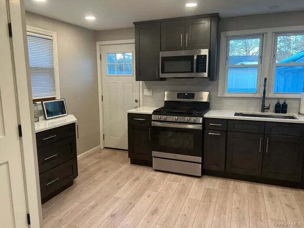 a kitchen with a stove a sink and a microwave