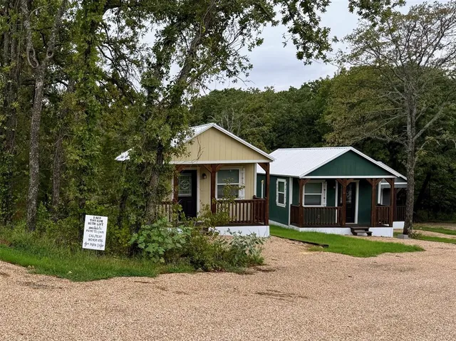 a front view of a house with a yard and trees