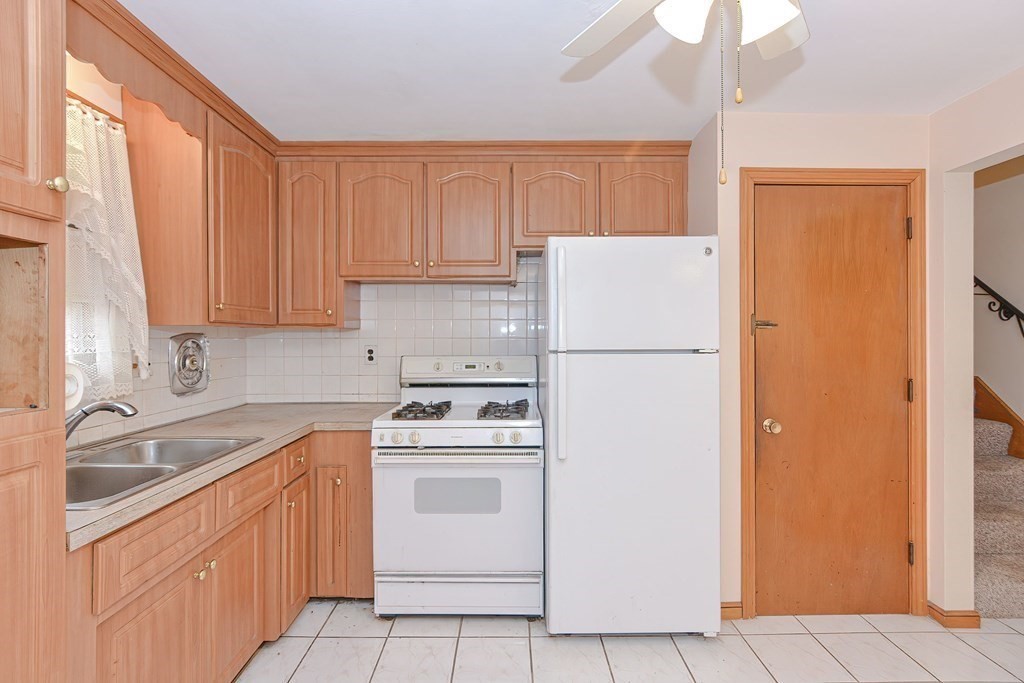 209 3rd Street Stoughton, MA 02072 - Photo 4 of 36 a kitchen with a refrigerator sink stove and cabinets