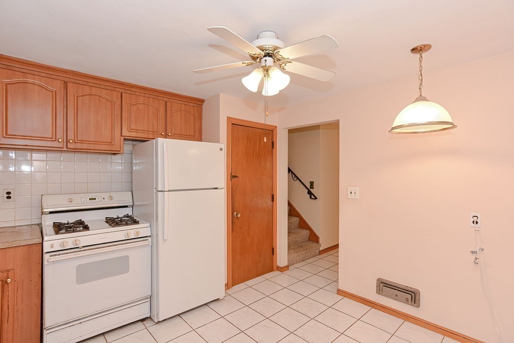 209 3rd Street Stoughton, MA 02072 - Photo 6 of 36 a kitchen with a refrigerator a stove top oven and cabinets