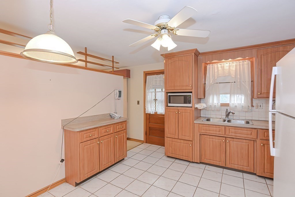 209 3rd Street Stoughton, MA 02072 - Photo 7 of 36 a kitchen with a sink stove and cabinets