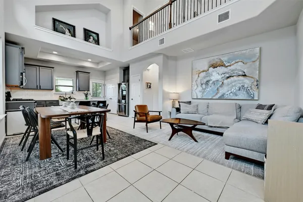 a living room with furniture a rug and kitchen view