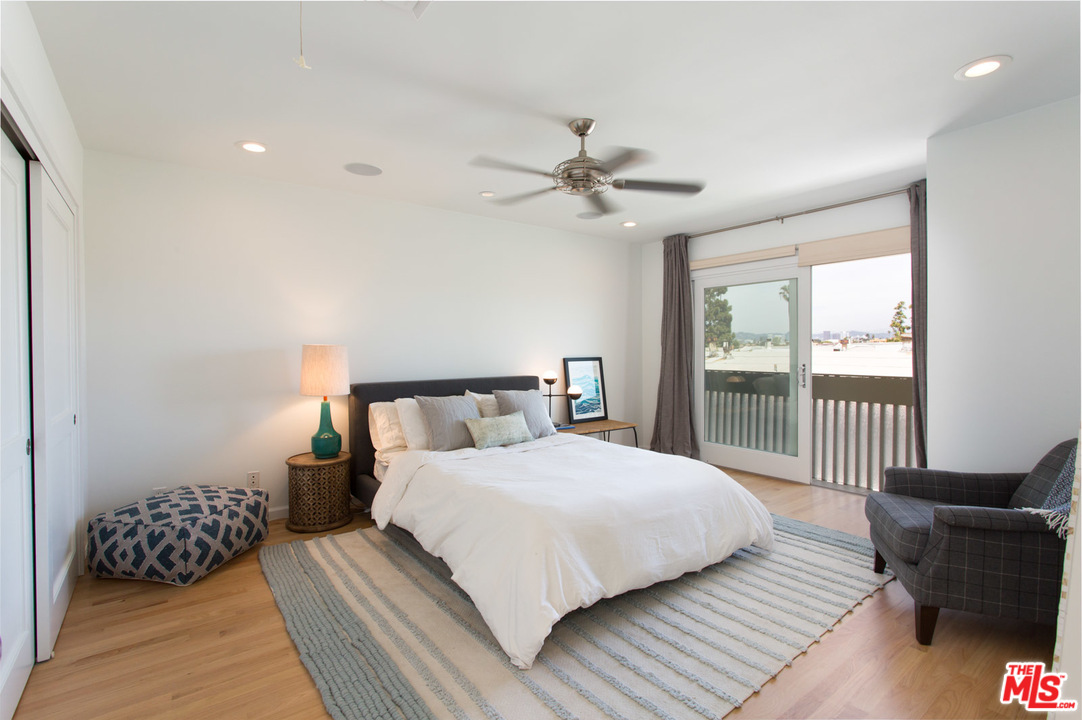631 Strand Street, Unit 2 Santa Monica, CA 90405 - Photo 12 of 30 a bedroom with a large bed chandelier and a window