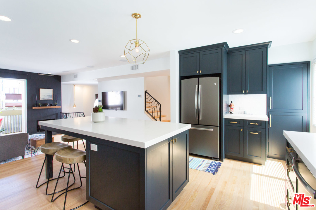 631 Strand Street, Unit 2 Santa Monica, CA 90405 - Photo 5 of 30 a kitchen with stainless steel appliances a table chairs and refrigerator