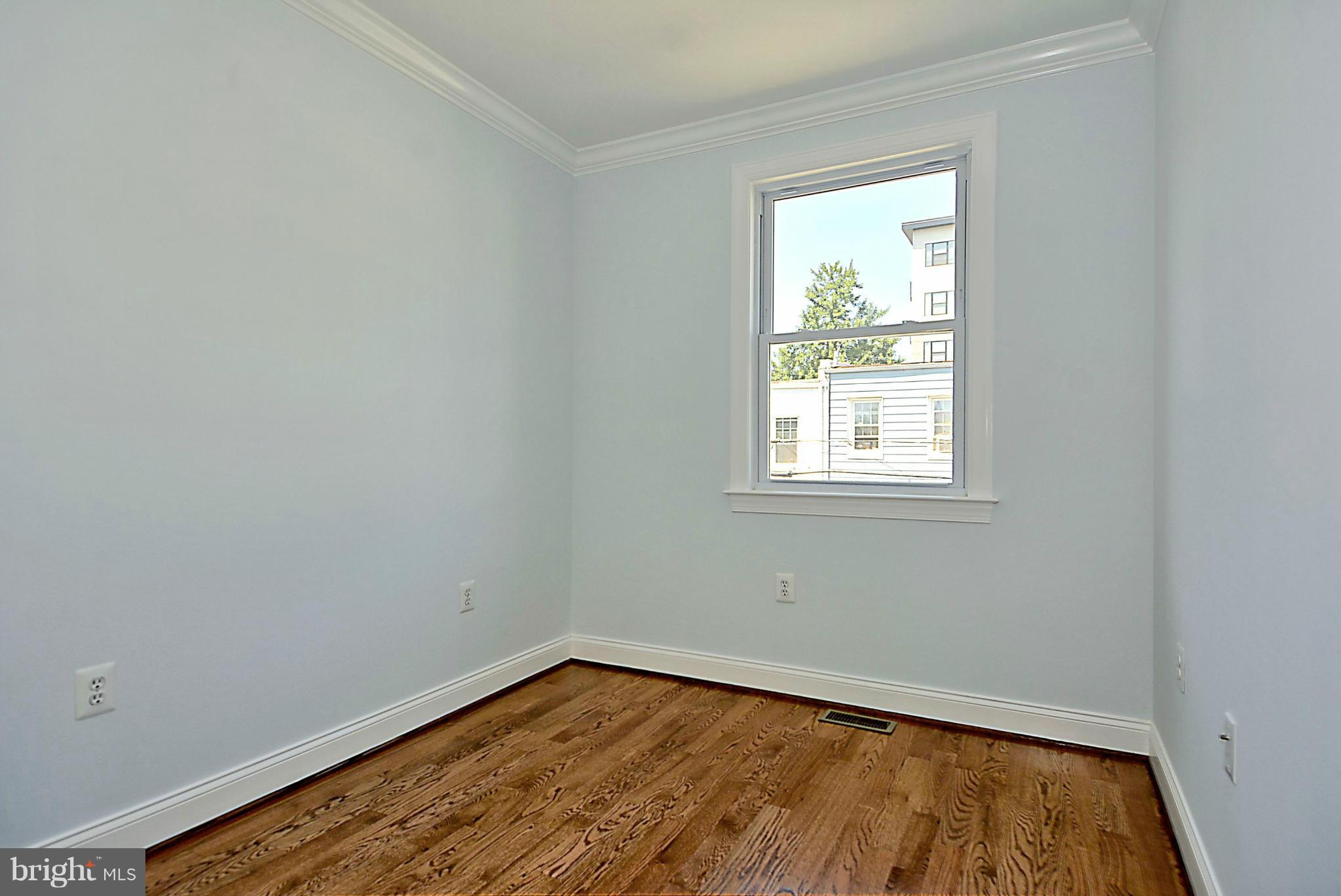 1102 4th Street Northeast Washington, DC 20002 - Photo 12 of 17 a view of an empty room with wooden floor and a window