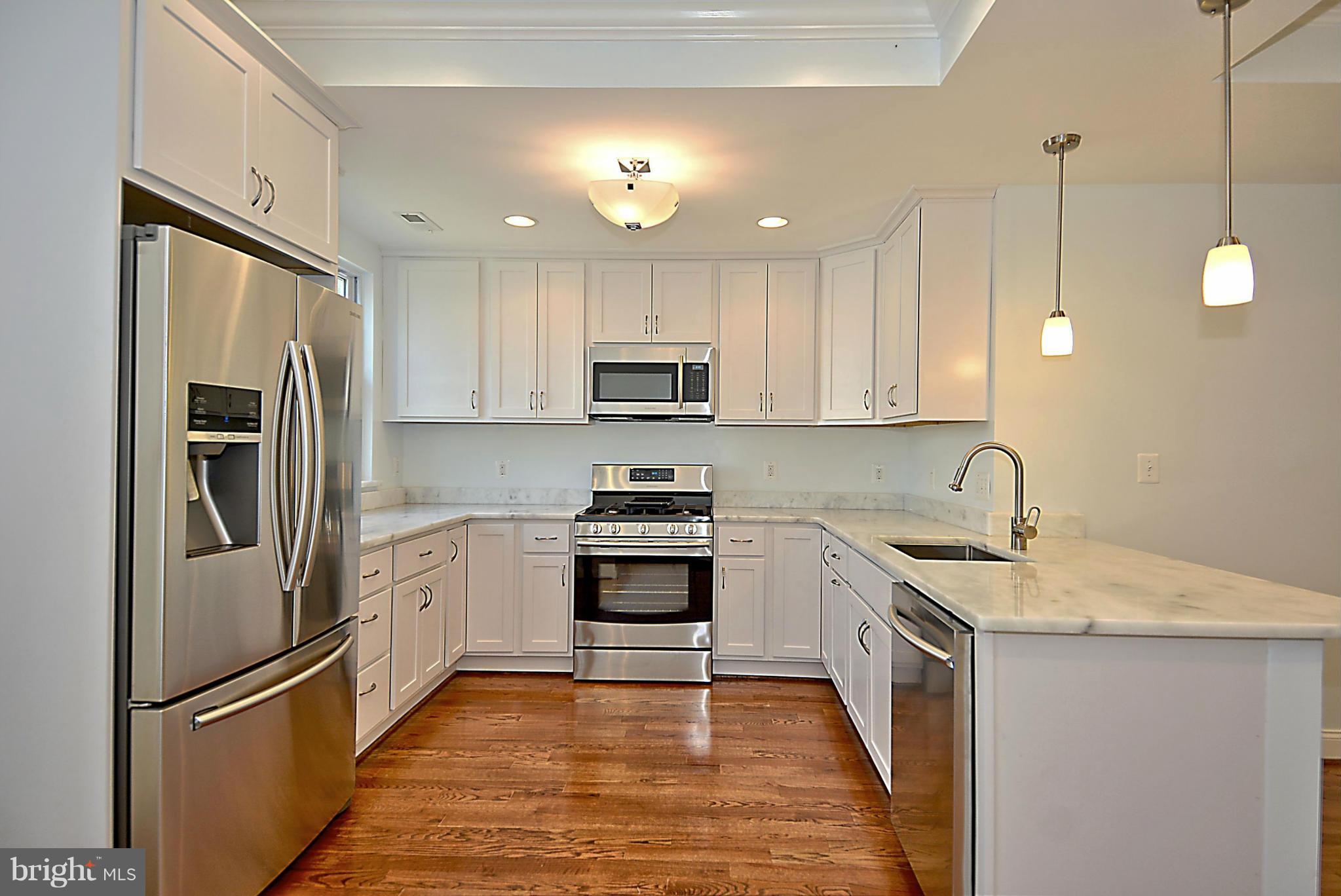 1102 4th Street Northeast Washington, DC 20002 - Photo 6 of 17 a kitchen with stainless steel appliances granite countertop a refrigerator sink and stove